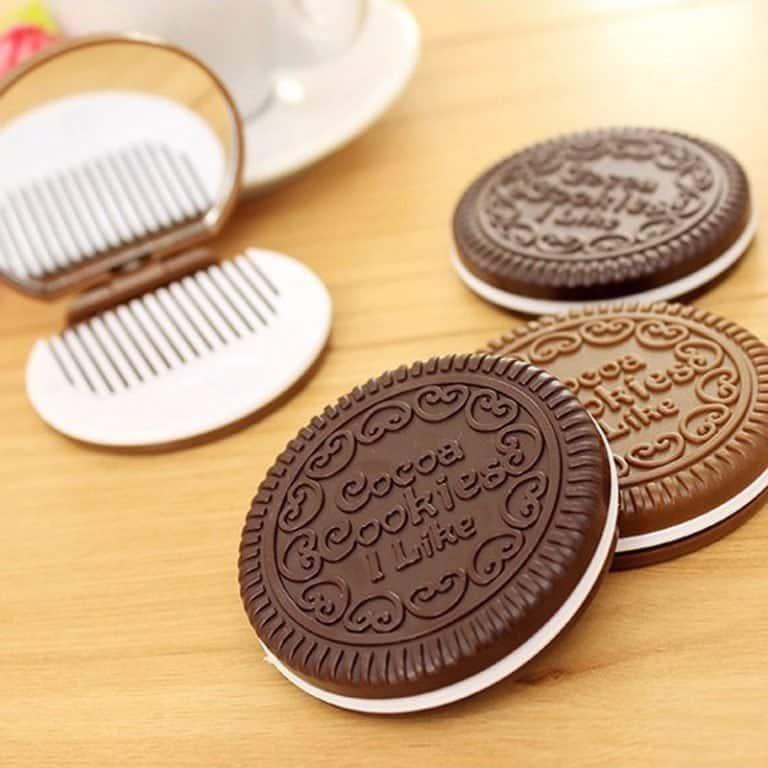 Four cookie-shaped mirror & hair comb sets on a wooden table 