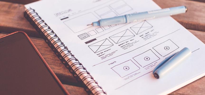 Website layout sketch in a notebook