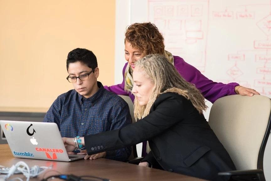 Photo of people looking at the laptop